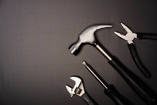 Composizione piana di una serie di utensili, tra cui martello, pinza, chiave inglese, cacciaviti e nastro di misura - Foto, immagini