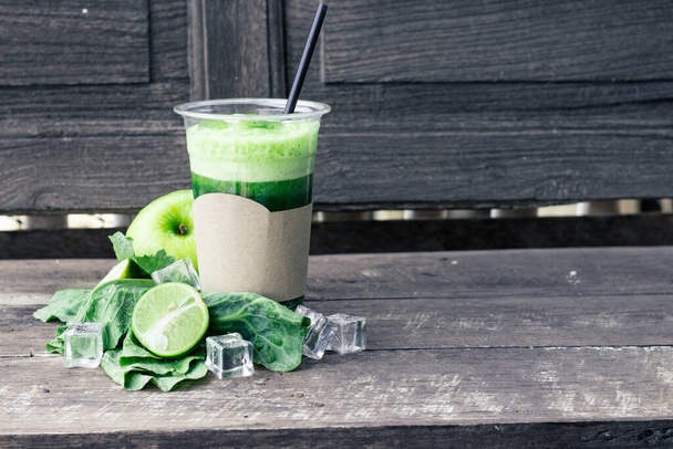Zelený jablečný koktejl ve skle a kapustové listy na venkovském dřevěném stole. Letní detox shake pozadí - Fotografie, Obrázek