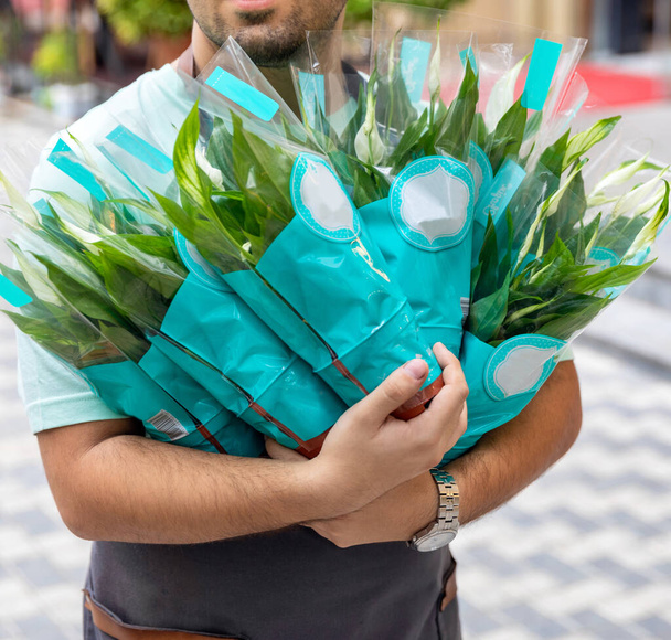 Чоловік тримає багато мирної лілії, Spathiphyllum, жіночого щастя - Фото, зображення