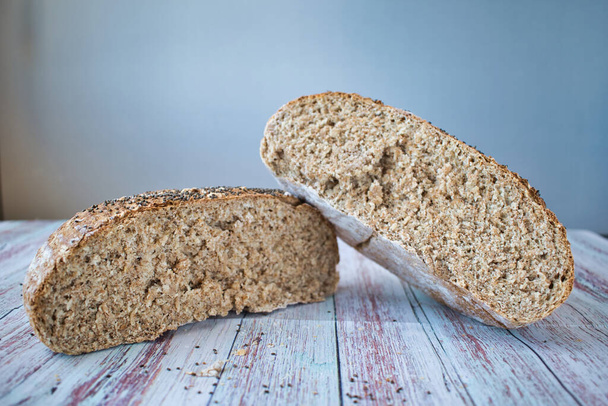 Ψωμί ολικής άλεσης με σπόρους τσία. Στρογγυλό ψωμί κομμένο στη μέση με λευκό φόντο - Φωτογραφία, εικόνα