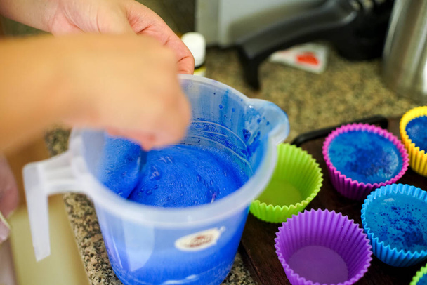Sciogliere il sapone in una tazza di plastica e aggiungere colori e profumi prima di versare in stampi in silicone colorato per fare sciogliere fatto in casa e versare sapone - Foto, immagini