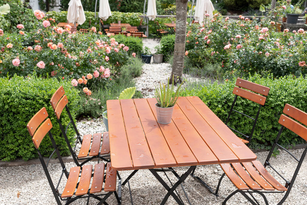Κενές καρέκλες και τραπέζια στον κήπο του εστιατορίου το καλοκαίρι - Φωτογραφία, εικόνα