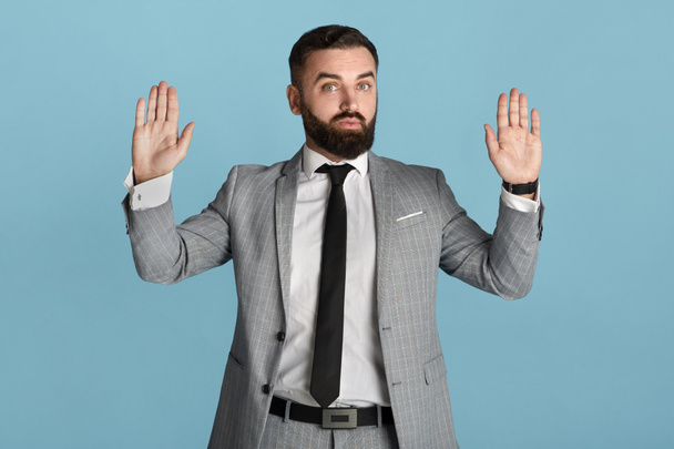 Руководитель офиса в формальной одежде показывает жест капитуляции на синем фоне
 - Фото, изображение