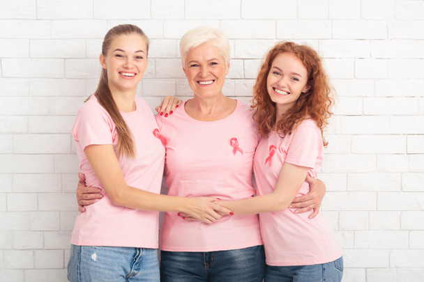 Three Breast Cancer Volunteers Ladies Hugging Over White Background - Zdjęcie, obraz