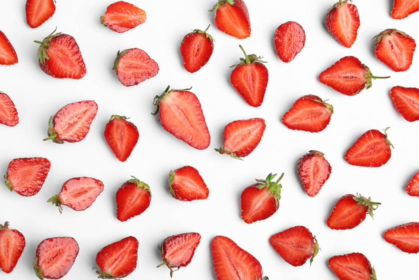Halves of delicious ripe strawberries on white background, flat lay - Foto, afbeelding