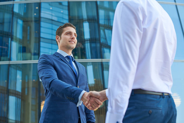 Business handshake outside the business center. Partnership meeting concept. Successful businessmen handshaking after good deal.  - Foto, Imagen