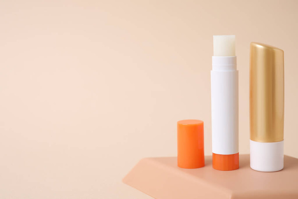 Hygienic lipsticks on beige background, space for text - Foto, Imagen
