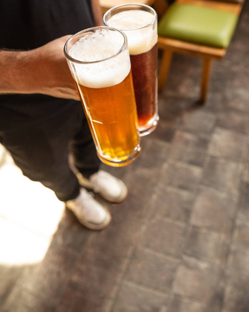 Man holding white and black beer side by side - Foto, Imagem