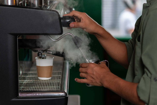 Mani che preparano un cappuccino, in una macchina da caffè espresso. - Foto, immagini