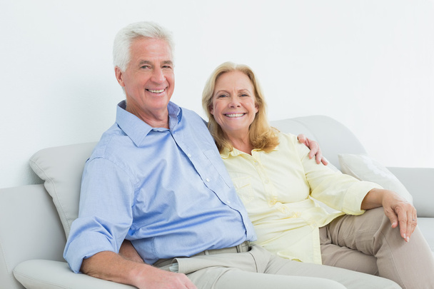 Happy loving senior couple sitting on sofa - Фото, изображение