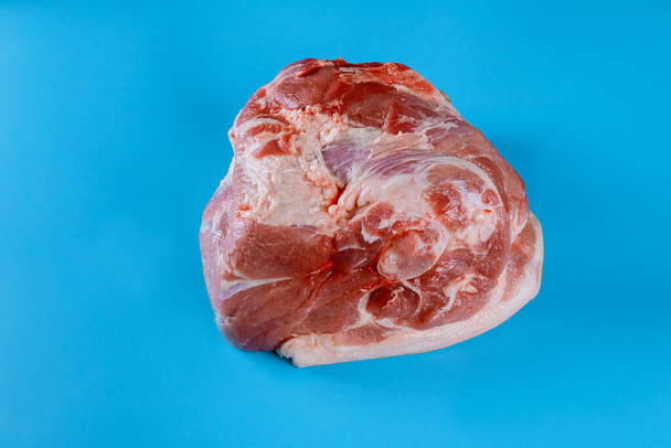 Perna de junta de porco crua isolada no fundo azul
 - Foto, Imagem