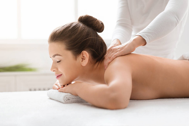 massagista esfregando jovem mulher ombros no spa
 - Foto, Imagem