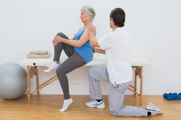 Male physiotherapist examining senior woman's back - Foto, imagen