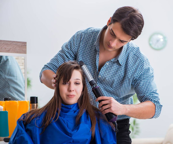 Man male hairdresser doing haircut for woman - Фото, зображення