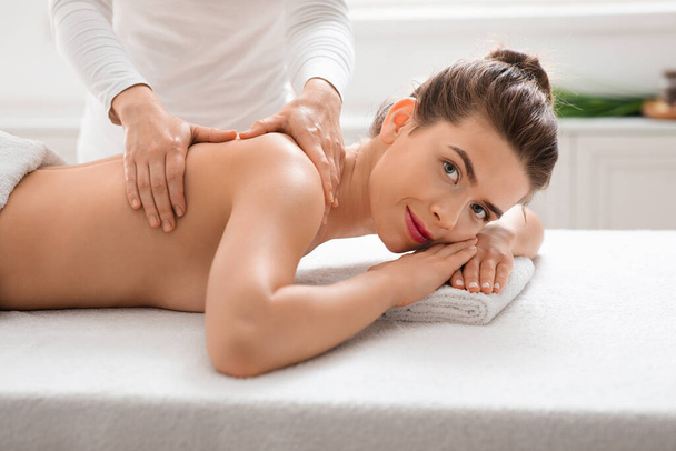Attraktive junge Frau bekommt Massage im Spa - Foto, Bild