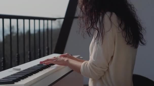 Mladá dívka muzikant hrát elektrické piano na balkóně - Záběry, video