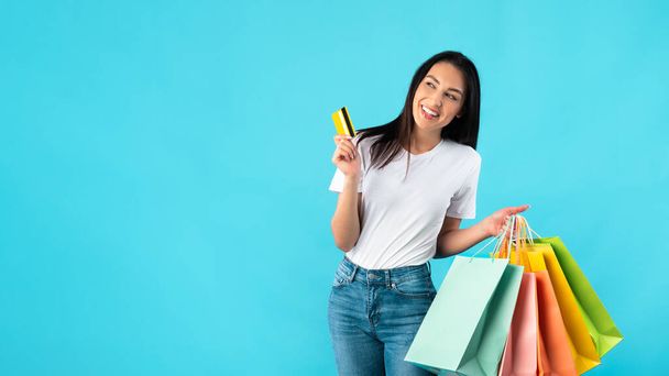 Uśmiechnięta kobieta z torbami na zakupy i plastikową kartą - Zdjęcie, obraz
