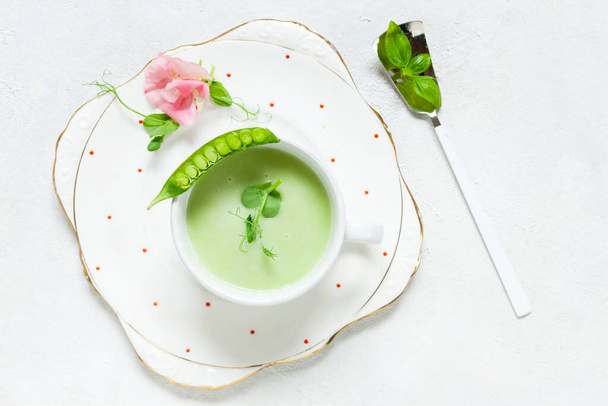 Soupe maison à la crème de pois verts frais avec pousses de pois et fleurs - Photo, image