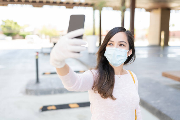 Metà donna adulta scattare selfie attraverso smartphone in città durante l'epidemia di coronavirus - Foto, immagini