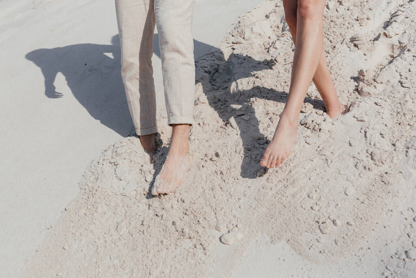 Happy young couple walking on the sand. Couple legs. Love story. High quality photo - Foto, Bild