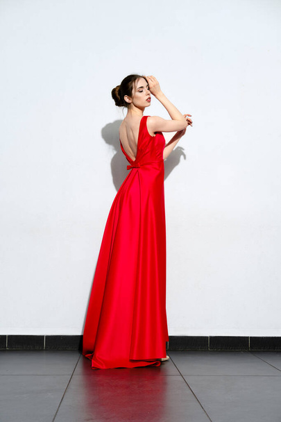 Charming girl in waiving red silk dress with straps - Zdjęcie, obraz