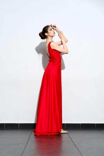 Charming girl in waiving red silk dress with straps - 写真・画像
