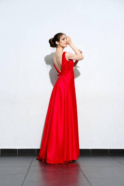 Charming girl in waiving red silk dress with straps - Zdjęcie, obraz
