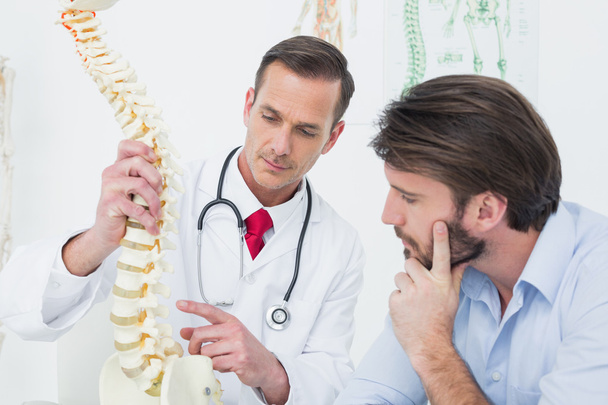 Male doctor explaining the spine to a patient - Photo, Image