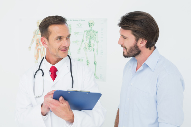 Male doctor discussing reports with patient - Foto, Imagem