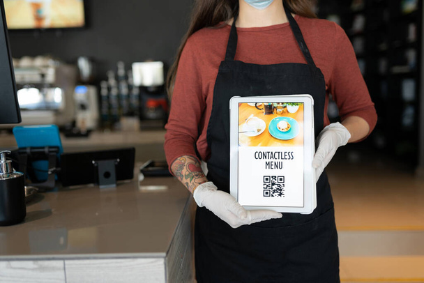 Naispuolisen henkilöstön keskiosa, joka näyttää kontaktitonta QR-koodia digitaalisessa tabletissa ravintolassa - Valokuva, kuva