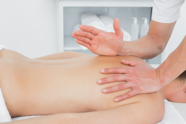 Close-up of a physiotherapist massaging woman's back - Photo, Image