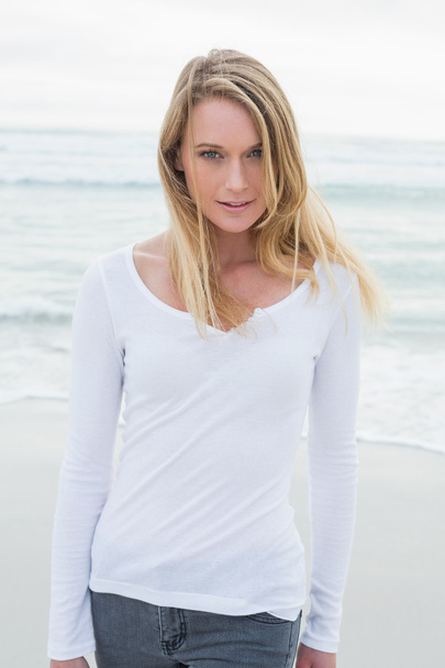 Portrait of a smiling casual woman at beach - Photo, Image