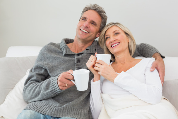 Relaxed couple with coffee cups in living room - Φωτογραφία, εικόνα