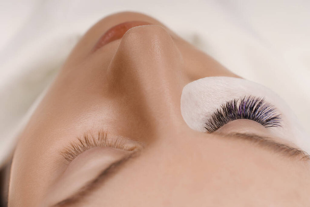 Eyelash Extension Procedure. Close up view of beautiful female eye with long eyelashes, smooth healthy skin. - Photo, Image