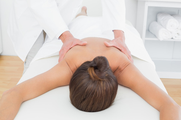 Male physiotherapist massaging woman's back - 写真・画像