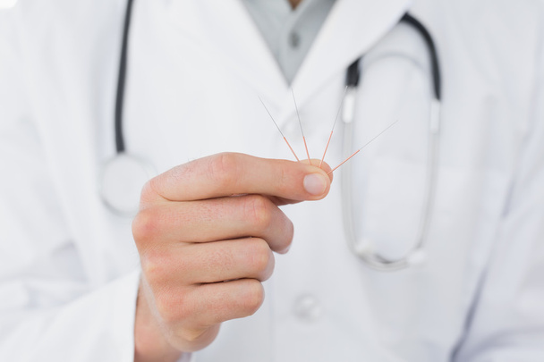 Mid section of a male doctor holding acupuncture needles - Photo, Image