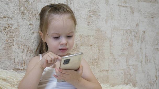 A small child is talking on the phone via video calling. Kid communicates remotely through a mobile application. Preschool education using the Internet. Close-up - Fotoğraf, Görsel