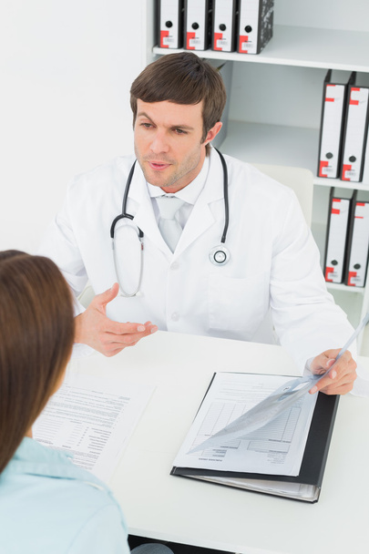 Doctor in conversation with female patient in medical office - Foto, afbeelding