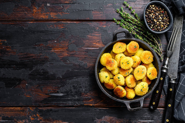 Fried gnocchi potato pasta. Black wooden background. Top view. Copy space. - Fotografie, Obrázek