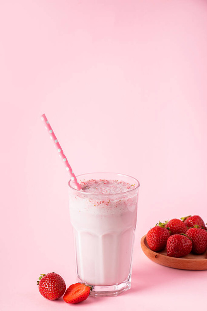Свежий молочный коктейль с клубникой на розовом фоне. Летняя детоксикация. Место для текста
. - Фото, изображение