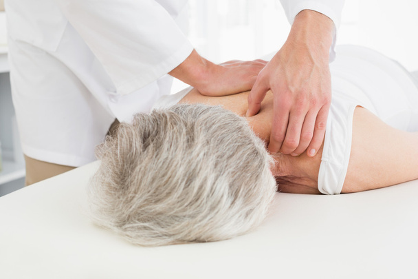 Физиотерапевт массирует спину пожилой женщине
 - Фото, изображение