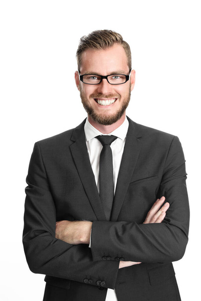 A successful and happy executive businessman wearing glasses, black suit and tie, and a white collared shirt with his arms crossed standing against white background - Zdjęcie, obraz