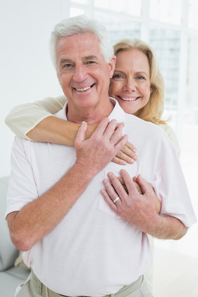 Happy senior woman embracing man from behind - Foto, imagen