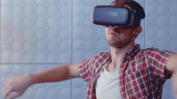 Man swim in a virtual pool or sea using modern vr glasses indoors. Handsome teenager guy wearing virtual reality headset trying to adjust reality. Modern technologies. Prores 422 - Filmati, video