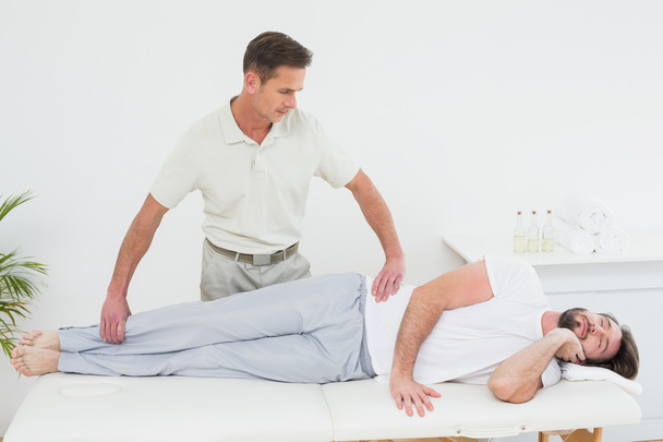 Male physiotherapist examining man's leg - Фото, зображення