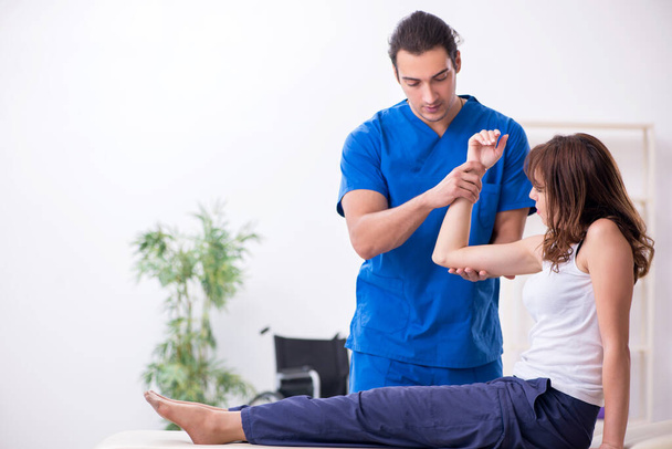 Injured woman visiting young male doctor osteopath - Foto, Imagem