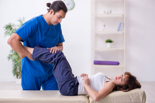 Injured woman visiting young male doctor osteopath - Photo, Image