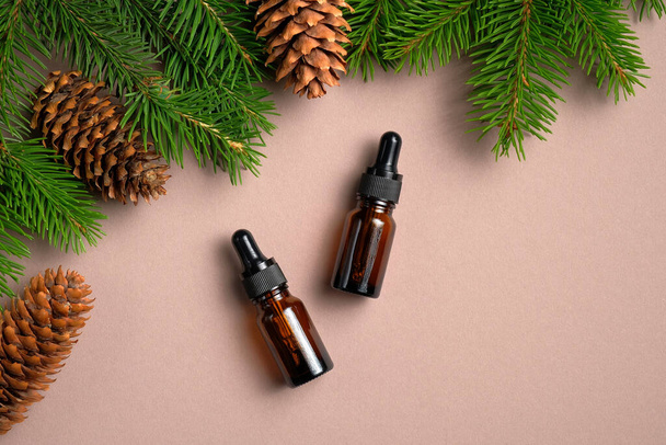 Flat lay composition with bottles of conifer essential oil on neutral table. Natural organic cosmetics for hair care. - Fotó, kép