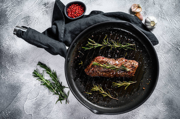 Grilled skirt, machete steak in a frying pan. Marble meat beef. Gray background. Top view. - Photo, Image