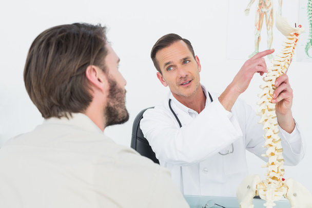 Male doctor explaining the spine to a patient - Photo, image